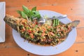 Whole fried snakehead fish, seasoned with chopped mango, lemongrass, chili, spring onions. Royalty Free Stock Photo