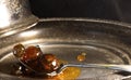 WHOLE FRUIT JAM ON A SPOON RESTING ON A METAL PLATTER WITH LID PRESENTING WITH A PATINA FINISH 