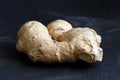 Whole ginger root on black slate.