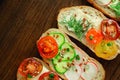 Whole grain bread or sandwiches with cheese, cucumber, radish, tomatoes, onion, dill, sunflower pumpkin seeds on wooden