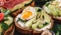 Whole grain bread sandwiches with fried quail egg, avocado, herbs and seeds on black background. Clean eating, healthy vegan