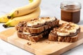 whole grain bread slices spread with nutella, garnished with banana slices Royalty Free Stock Photo