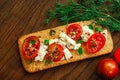 Whole grain cookies, thin crisp bread, with cheese, tomatoes, green onion and flaxes seeds on natural wood background