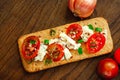 Whole grain cookies, thin crisp bread, with cheese, tomatoes, onion and flaxes seeds on natural wood background