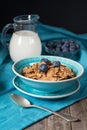 Whole grain flakes with blueberries, jug of milk and fresh berries on wooden table, healthy breakfast Royalty Free Stock Photo