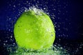 Whole green apple with stopped motion water drops