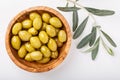 Whole green olives in wooden bowl on white background. Top view, close-up Royalty Free Stock Photo