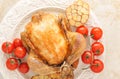 Whole grilled chicken on a plate with tomatoes and garlic Royalty Free Stock Photo