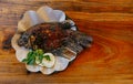 Whole grilled gourami fish on a plate with brown oil paper. Copy space.