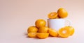 Whole and half cut fresh oranges with white ceramic mug on soft cream background Royalty Free Stock Photo