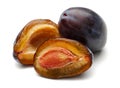 Whole and half Damson plums isolated on white Royalty Free Stock Photo