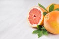 Whole and half pink grapefruit closeup on white wood background. Royalty Free Stock Photo