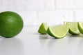 whole and half with slice of fresh green lime on white background