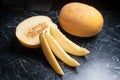 Whole, half and sliced honeydew melon fruit on dark marble background. Royalty Free Stock Photo