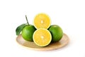 Whole and half sweet oranges on round wooden tray on white backg