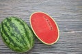 Whole and half watermelon on wooden background