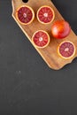 Whole and halved blood oranges on black background, top view. Flat lay, overhead, from above. Copy space Royalty Free Stock Photo
