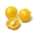 Whole and halved fresh heirloom variaty of yellow Mountain Vesuvius tomatoes on white background