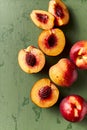 Whole and halved nectarines on rustic painted background