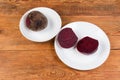 Whole and halves boiled red beetroots on two different dishes