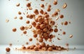 Whole hazelnuts and fragments explode in midair, scattering across a clean studio background. Scattered nuts form a pile on a Royalty Free Stock Photo