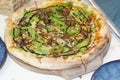 Whole Italian pizza with bacon and arugula,