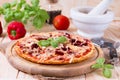 Whole italian pizza on wood table with ingredients