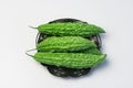 Whole karela bitter melon caraili studio close up white background inside metal basket