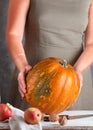 Whole large organic pumpkin in women`s hands