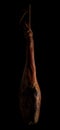 Whole leg of Spanish Iberian serrano ham hanging on a rope. Royalty Free Stock Photo