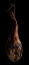 Whole leg of Spanish Iberian serrano ham hanging on a rope. Royalty Free Stock Photo