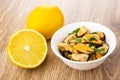 Whole lemon and half of lemon, mussels with parsley in bowl on table Royalty Free Stock Photo