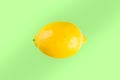 Whole lemon laying on green background