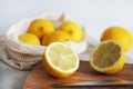 Whole lemons next to cut ones on a wooden board next to a knife Royalty Free Stock Photo