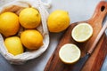 Whole lemons next to cut ones on a wooden board next to a knife Royalty Free Stock Photo