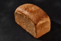 Whole loaf of fresh, palatable baked white bread against black background with copy space. Close-up Royalty Free Stock Photo