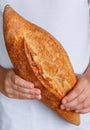 Whole loaf of freshly baked wheat bread in children`s hands Royalty Free Stock Photo