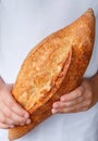 Whole loaf of freshly baked wheat bread in children`s hands Royalty Free Stock Photo