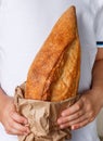 Whole loaf of freshly baked wheat bread in children`s hands Royalty Free Stock Photo