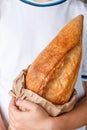 Whole loaf of freshly baked wheat bread in children`s hands Royalty Free Stock Photo