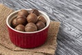 Whole macadamia nuts in red bowl