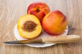 Whole nectarines, half of nectarine and knife in plate Royalty Free Stock Photo