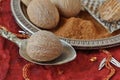 Whole nutmeg and nutmeg powder on spoon and plate