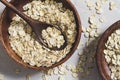 Whole oat flakes in wooden bowls on a light cement background, tinted Royalty Free Stock Photo