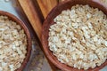 Whole oat flakes in wooden bowls on a light cement background, tinted Royalty Free Stock Photo