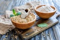 Whole oats and oat flour in wooden bowls.