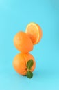 Whole orange with a green leaf and on it an orange cut in half on a blue background. Summer concept citrus, refreshing juice Royalty Free Stock Photo