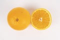 Whole orange and its cut half are placed side by side on a white background flat lay Royalty Free Stock Photo