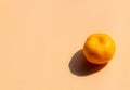 A whole oranges with strong shadow on orange background