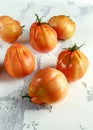 Whole organic tomatoes Coeur De Boeuf. Beefsteak tomato on white rustic table